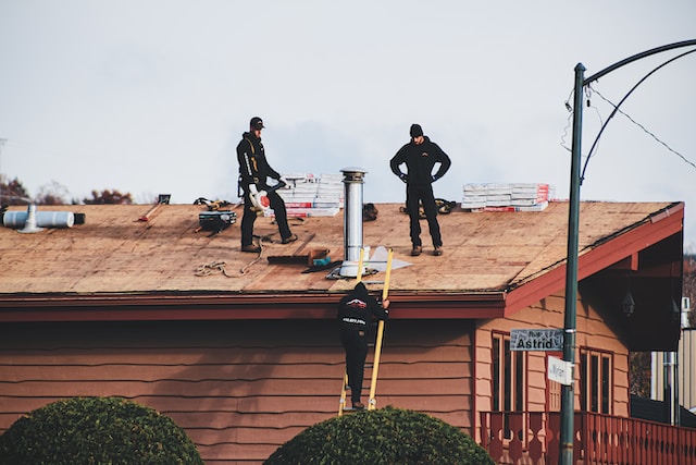Roof repairmen assessing roof condition